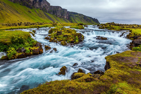沿着环岛的第一号高速公路宽而美丽的山谷。冰岛强大的瀑布。七月旅行。积极和极端旅游的概念