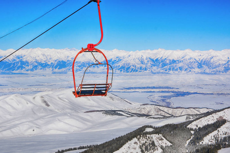 橙色的椅子被一个令人惊叹的冬季景观包围着蓝天和山脉。