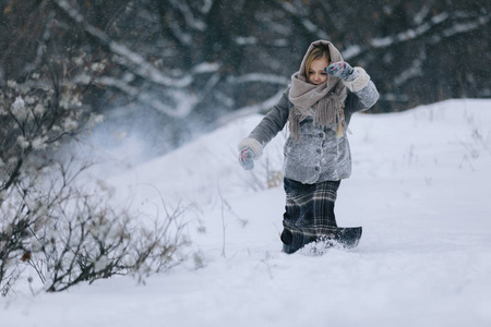 可爱的小女孩在树林里的冬天。下雪