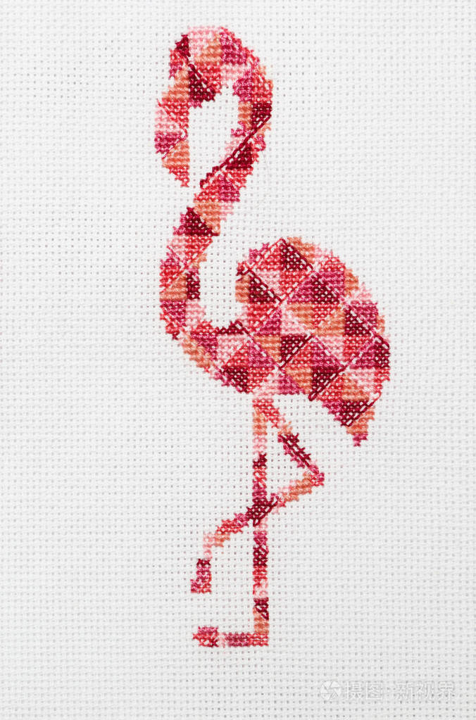 粉红色火烈鸟刺绣在白色织物上。