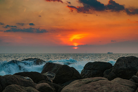 日落时海浪在岩石上破碎。 夕阳在海洋中，海浪在岩石上破碎。