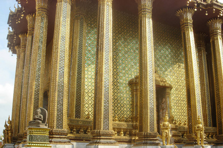 泰国的金庙。 东方神在华丽的装饰建筑前面。 户外复制空间。