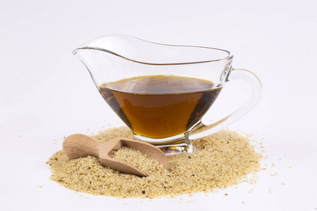 芝麻油和芝麻籽黑色和白色的芝麻籽一碗芝麻酱酱和芝麻籽在白色背景下