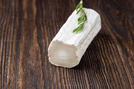 切片圆白色自制山羊奶酪传统牛奶奶油乳制品上的老式木板。 乡村风格。