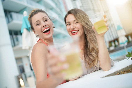 在城市的屋顶酒吧里，两个有吸引力的爱好有趣的朋友在聚会上喝酒