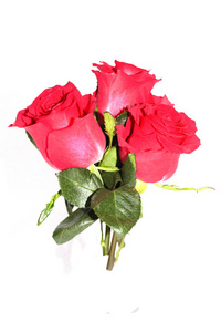 一束三朵红玫瑰躺在白色的背景上。 适合贺卡的照片。