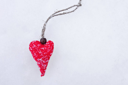 手工制作的红色毛毡心脏在白色纯净的雪