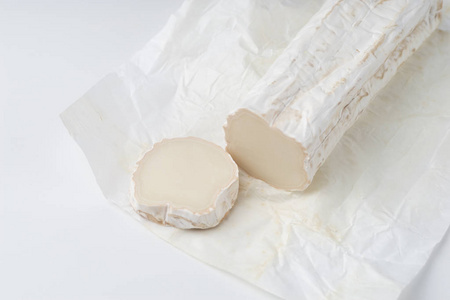 在白色背景上用迷迭香切片山羊奶酪和山羊奶酪片。 烹饪奶酪吃。