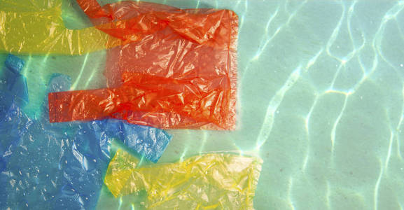海水中五颜六色的包裹。 污染概念。