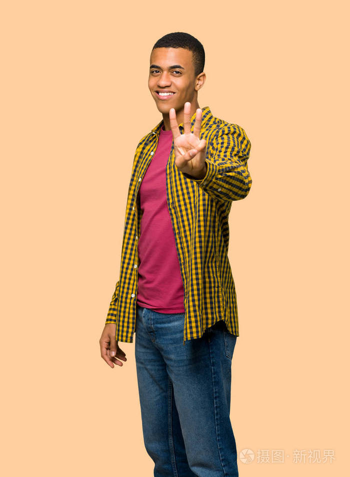 年轻的美国黑人男子快乐,用手指在孤立的背景上数三下