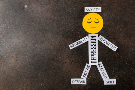 心理疾病. 黑暗背景下悲伤微笑和抑郁症状的小男人. 顶部视图照片