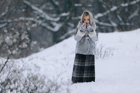 可爱的小女孩在树林里的冬天。下雪