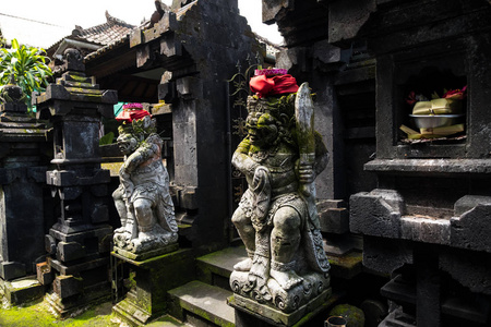 巴厘岛寺庙前面的石像和祭祀祭品。