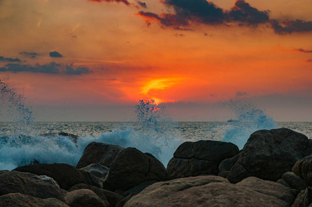 日落时海浪在岩石上破碎。 夕阳在海洋中，海浪在岩石上破碎。