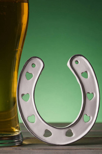 s Day beer and lucky horseshoe against a green background