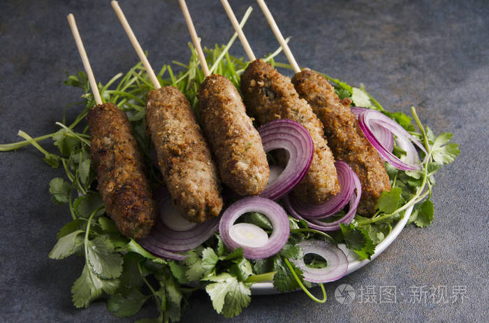烤串与香料,洋葱圈在黑暗的乡村餐桌上