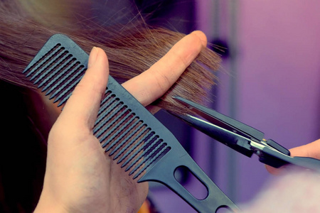 理发师割伤吐口水结束头发与热剪刀。手特写