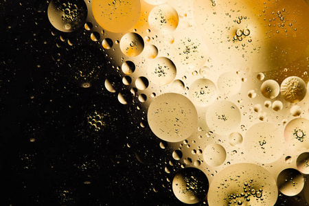 油滴分子在水中创造的抽象图案包含不同颜色和色调的油滴.照片