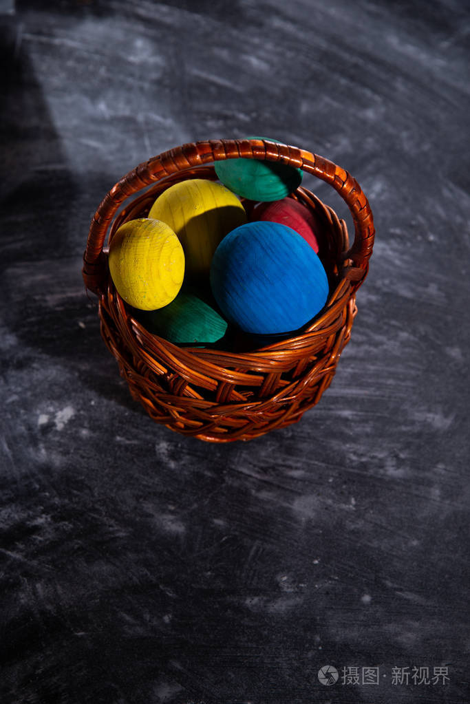复活节五颜六色的鸡蛋在一个篮子在黑暗的模糊的背景