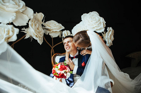 情侣婚纱结婚照新娘和新郎穿着一件漂亮的裙子,坐在一张白色的老式