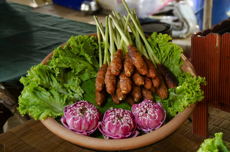 泰国菜，炸鱼泥或鱼与香料混合，咖喱蛋糕，裹在柠檬草上，装在篮子里，竹子里，供出售，旅行者在小市场上，复古风格的人在唱布里，泰国