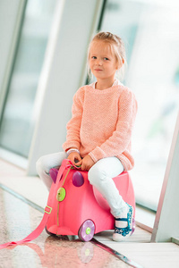 可爱的小女孩在机场等待登机她行李