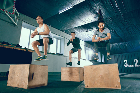 一群运动肌肉发达的人正在健身房锻炼