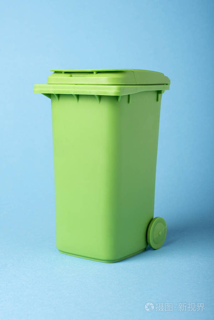 蓝色背景上的绿色垃圾箱. 回收利用.