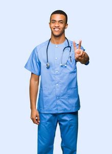 外科医生男子微笑，在孤立的背景上显示胜利标志