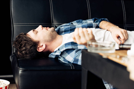 疲倦的人躺在沙发上宿醉的选择性注意力