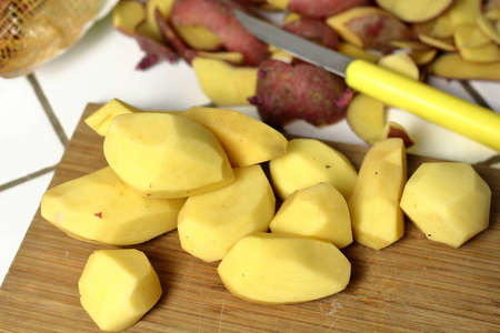 一种去皮生土豆，一种素食成分，用于在土豆皮旁边的木板上做饭，还有一把刀，用于在厨房里剥土豆。 晚餐准备过程