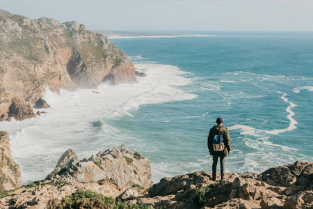 在葡萄牙的罗卡角, 一名背着背包的游客孤寂地站着