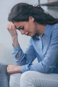 伤心的女人头痛伤心在家哭泣