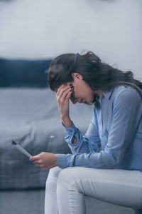 委屈哭泣照片有选择地集中注意力,悲伤的女人坐在家里拿着照片哭泣