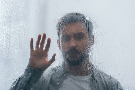 雨滴在窗户上的选择性聚焦，让人在背景上心烦意乱