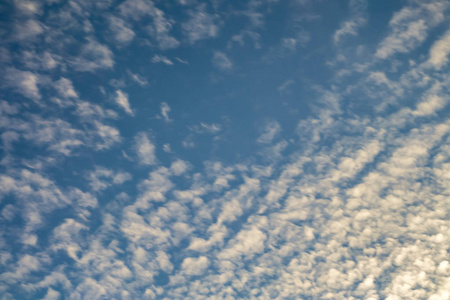 晚上和一天蓝色的天空背景,晚上有微小的卷曲翻滚的云.