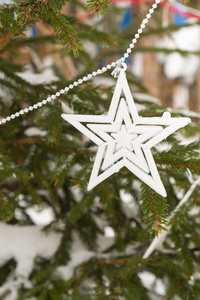 冬天，白色星星的花环挂在外面的树上
