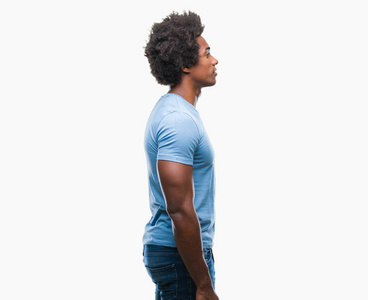 美国黑人男子在孤立的背景下，看着侧面放松的轮廓姿势，自然的脸，自信的微笑。
