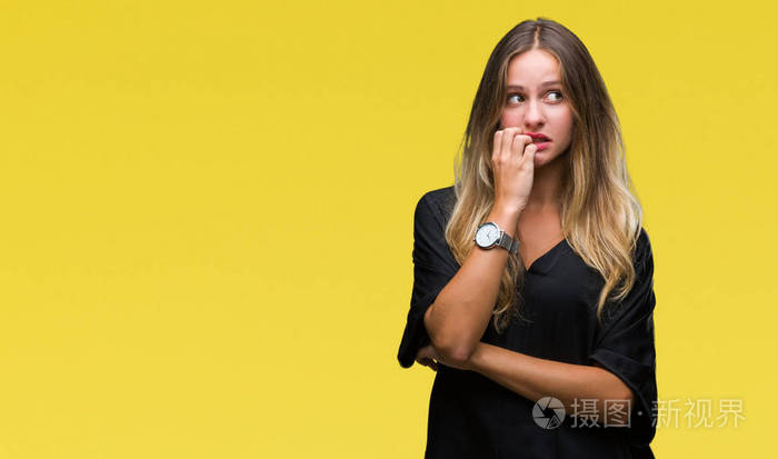 年轻漂亮的金发女人在孤立的背景上看着压力和紧张，双手咬着嘴的指甲。 焦虑问题。