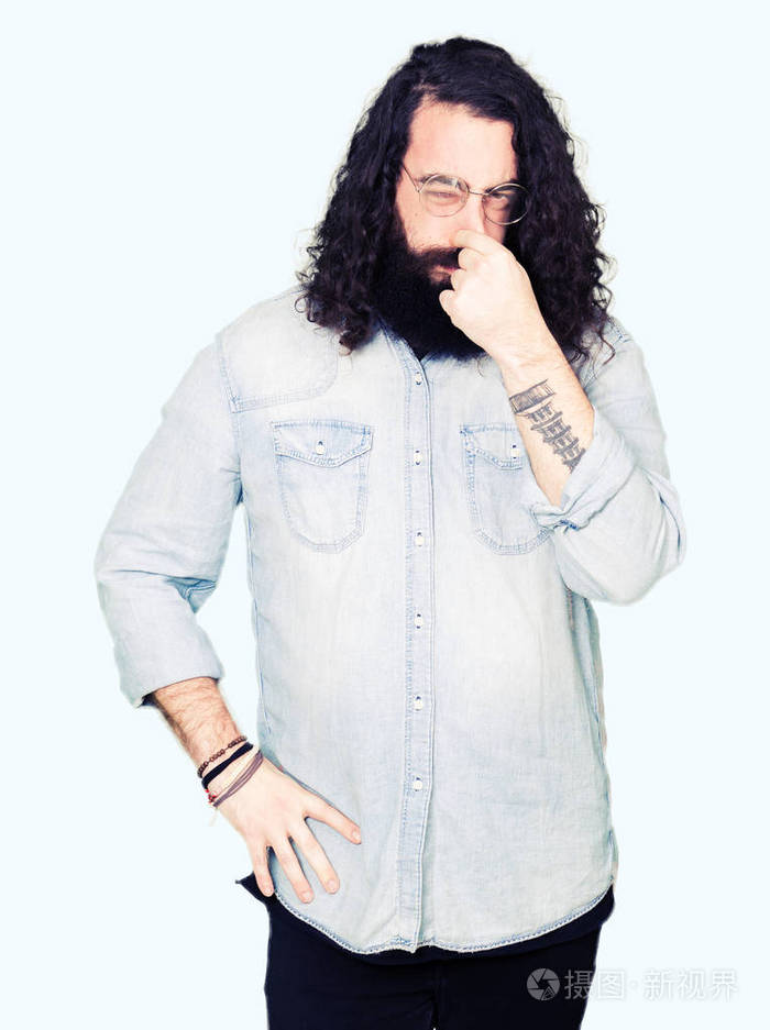 年轻的嬉皮士,留着长发和胡须,戴着眼镜,闻着一些臭味,令人恶心,难以