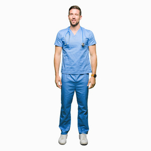 英俊的医生男人穿着医疗制服在孤立的背景上眨眼，看着镜头，的表情，开朗和快乐的脸。