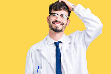 年轻的职业科学家穿着白大褂的男人，在孤独的背景下微笑，自信地抚摸头发，用手势摆出迷人的姿势