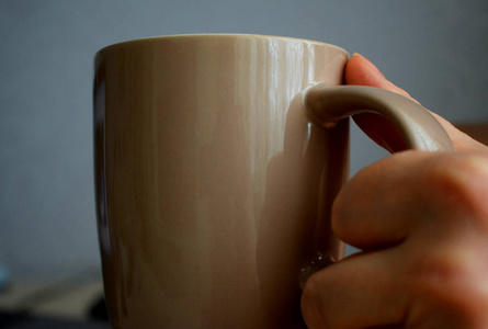 木制背景的手中咖啡杯