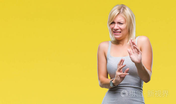 年轻漂亮的金发女人在孤立的背景下厌恶的表情不高兴和恐惧的做厌恶的