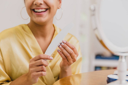 年轻的女人笑了。早上醒来快乐的女孩在卧室里的头上戴着毛巾。良好的肤色