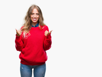 美丽的年轻金发女人穿着冬天的毛衣，在孤立的背景上，成功的标志，用手竖起大拇指，微笑和快乐地做积极的手势。 用欢快的表情看着相机，