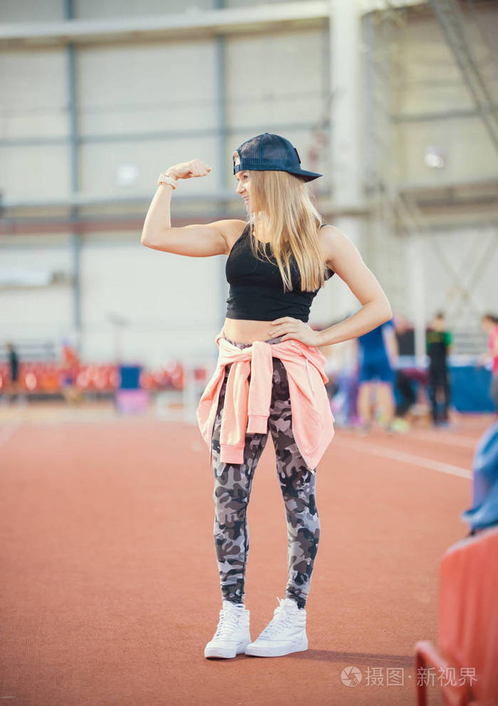 年轻的健康运动的女人显示她的手臂肌肉