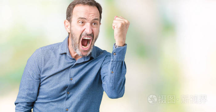 英俊的中年优雅的高级男人在孤立的背景下愤怒和疯狂地举起拳头,沮丧