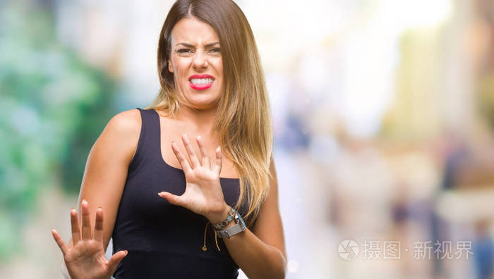 年轻的美女在孤立的背景下,厌恶的表情,不高兴和恐惧的做厌恶的脸