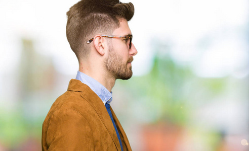 年轻英俊的商人戴着眼镜,看着侧面放松的轮廓,自然的脸,自信的微笑.